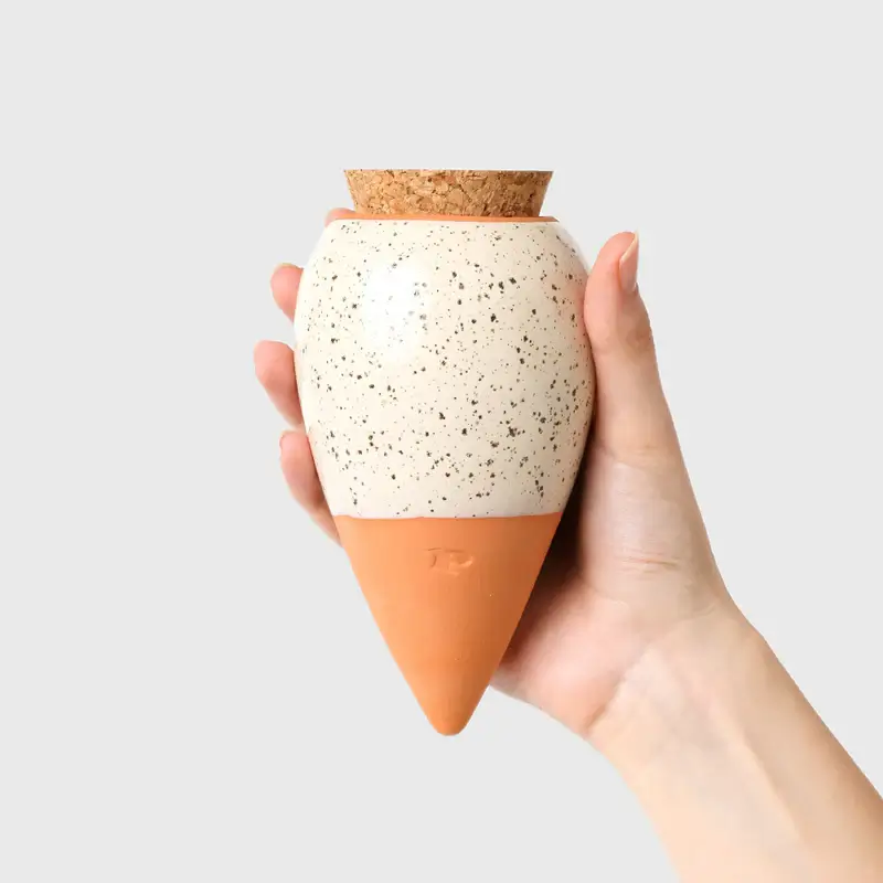 olla pépin blanc grainé tenu dans une main