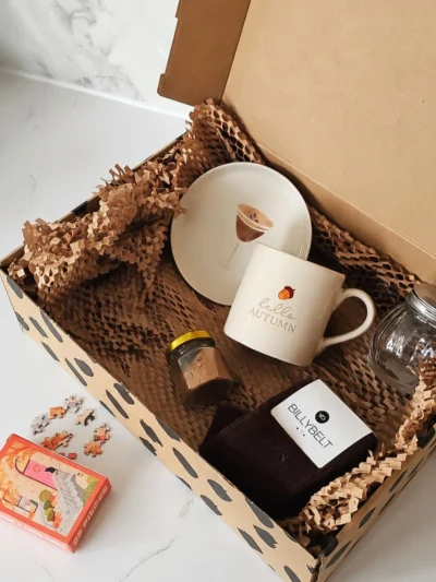 box essentiel d'automne avec une assiette, un mug, une paire de chaussettes, des épices et un mini puzzle